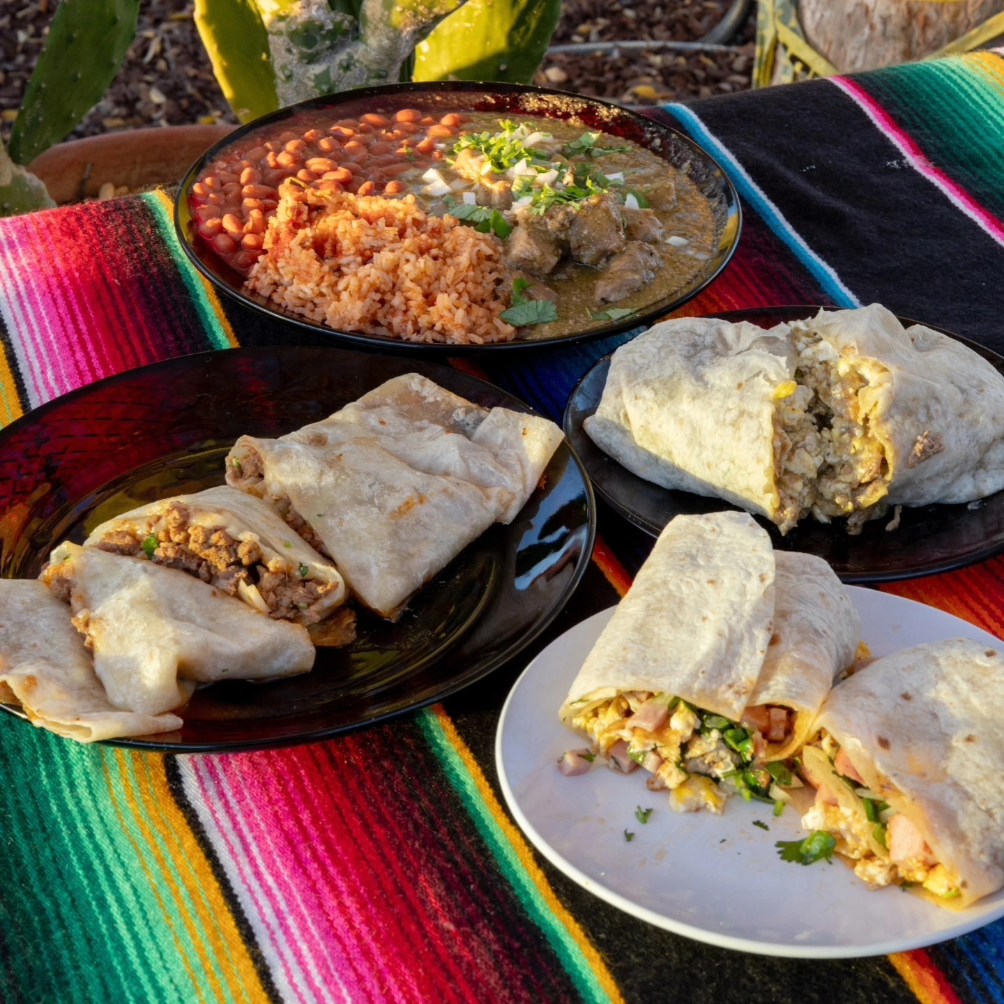 Breakfast burritos with eggs, ham and bacon alongside a chili verde plate with rice and beans